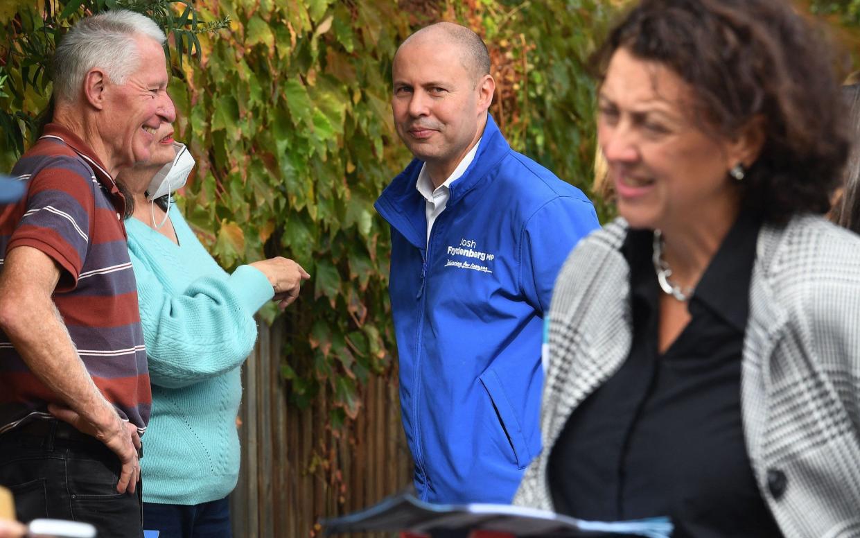 Josh Frydenberg (centre), Australia's treasurer, is battling to retain his usually safe seat of Kooyong from independent candidate Dr Monique Ryan (right) - WILLIAM WEST/AFP