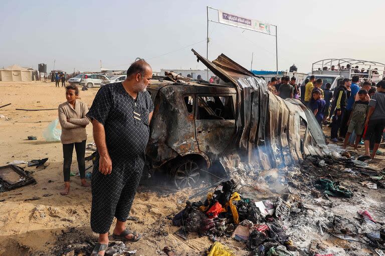 Palestinos se reúnen en el lugar de un ataque israelí en un área de campamento que alberga a desplazados internos en Rafah el 27 de mayo de 2024