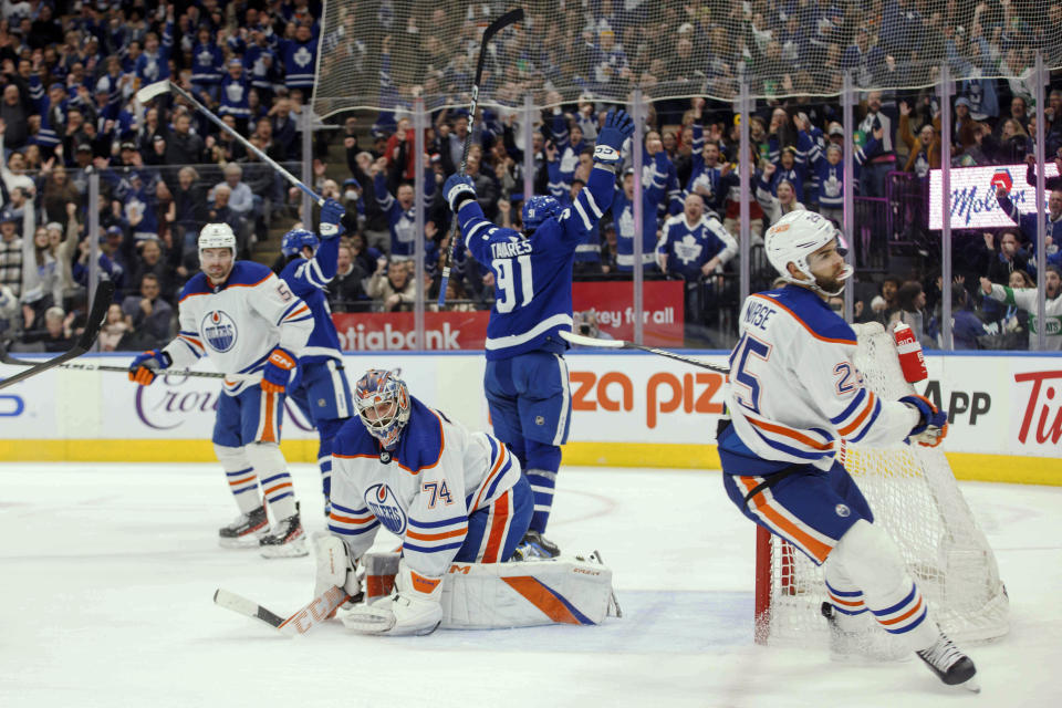 Edmonton Oilers goaltender Stuart Skinner (74) looks on as Toronto Maple Leafs center John Tavares (91) celebrates his goal during the second period of an NHL hockey game in Toronto, Saturday, March 11, 2023. (Cole Burston/The Canadian Press via AP)