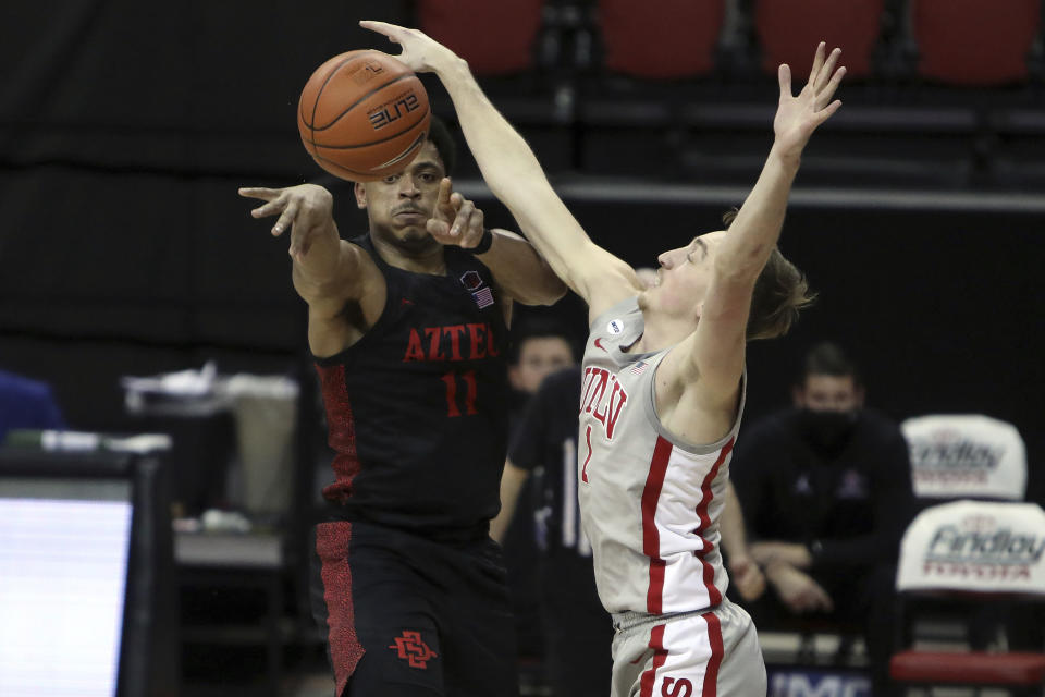 San Diego State's Matt Mitchell (11) passes the ball against UNLV's Moses Wood (1) during the second half of an NCAA college basketball game Wednesday, March 3, 2021, in Las Vegas. (AP Photo/Joe Buglewicz)