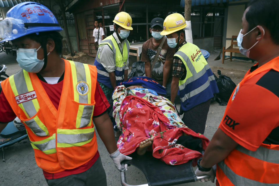 Members of a volunteer rescue team carry the body of a woman on a stretcher in Mandalay, Myanmar, Sunday, March 14, 2021. At least four people were shot dead during protests in Myanmar on Sunday, as security forces continued their violent crackdown against dissent following last month's military coup. (AP Photo)