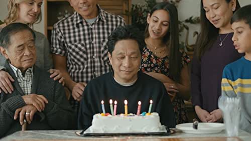 Still of cast Islands man blowing out birthday cake