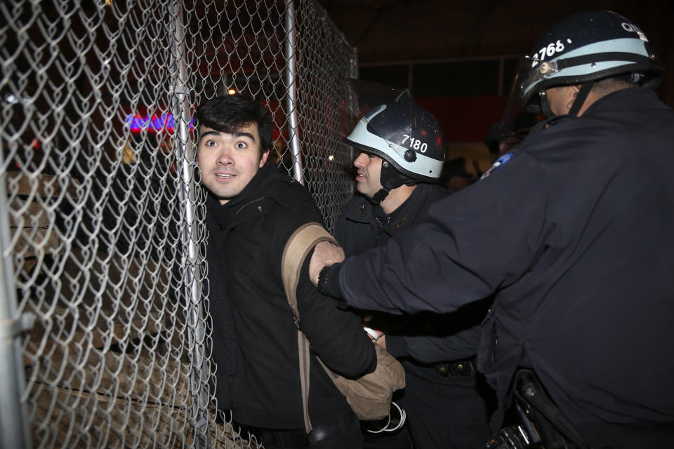 Protestor Michael Alvarez is arrested during a march against a grand jury's decision not to indict the police officer involved in the death of Eric Garner, Friday, Dec. 5, 2014, in New York. A grand jury cleared a white New York City police officer Wednesday in the videotaped chokehold death of Garner, an unarmed black man, who had been stopped on suspicion of selling loose, untaxed cigarettes, a lawyer for the victim's family said. (AP Photo/John Minchillo)