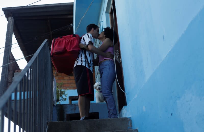 Erik Thiago kisses his wife before going to work, in Sao Paulo