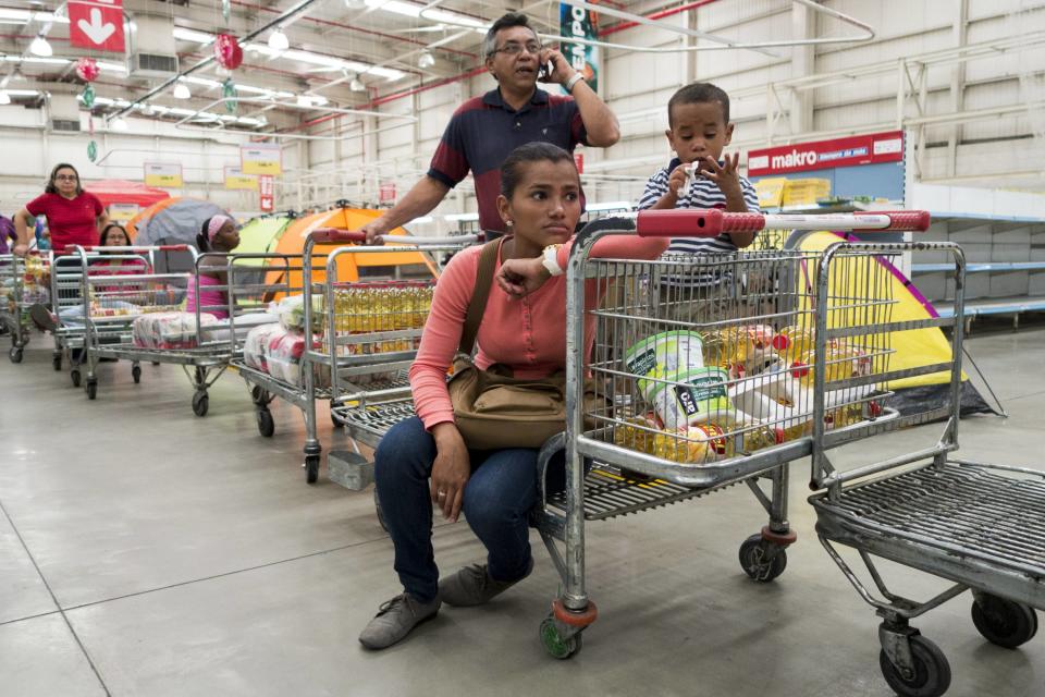 People line up to pay inside a Makro supermarket in Caracas January 9, 2015. Lines are swelling at Venezuelan supermarkets, with some shoppers showing up before dawn in search of products ranging from chicken to laundry detergent, as a holiday slowdown in deliveries sharpened the nation's nagging product shortages. Queues snaked around the block at grocery stores and pharmacies around the country on Friday, with consumers in some cases gathering before dawn under the gaze of National Guard troops posted to maintain order. REUTERS/Jorge Silva (VENEZUELA - Tags: POLITICS)