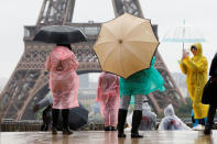 Tourists stroll on the Trocadero square, in front of the Eiffel Tower during a rainy day in Paris, France, May 30, 2016. REUTERS/Charles Platiau