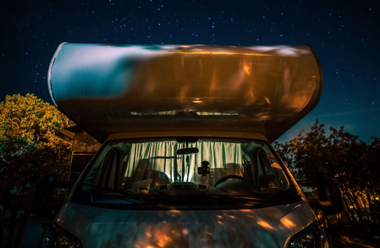 Night in RV Camper Van Motorhome Under Starry Sky. Motor Coach Front View.  Road Travel Vistas Theme.