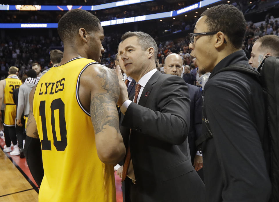FILE - Virginia coach Tony Bennett, center, congratulates UMBC's Jairus Lyles, left, after a first-round game in the NCAA men's college basketball tournament in Charlotte, N.C., Friday, March 16, 2018. (AP Photo/Gerry Broome, File)