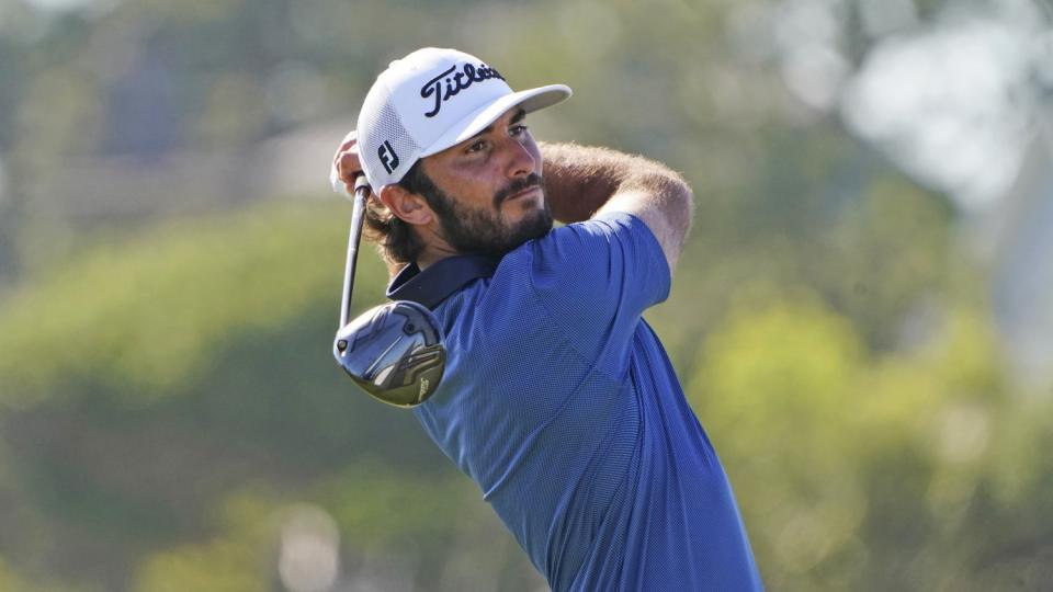 Max Homa watches his tee shot with his club over his shoulder.