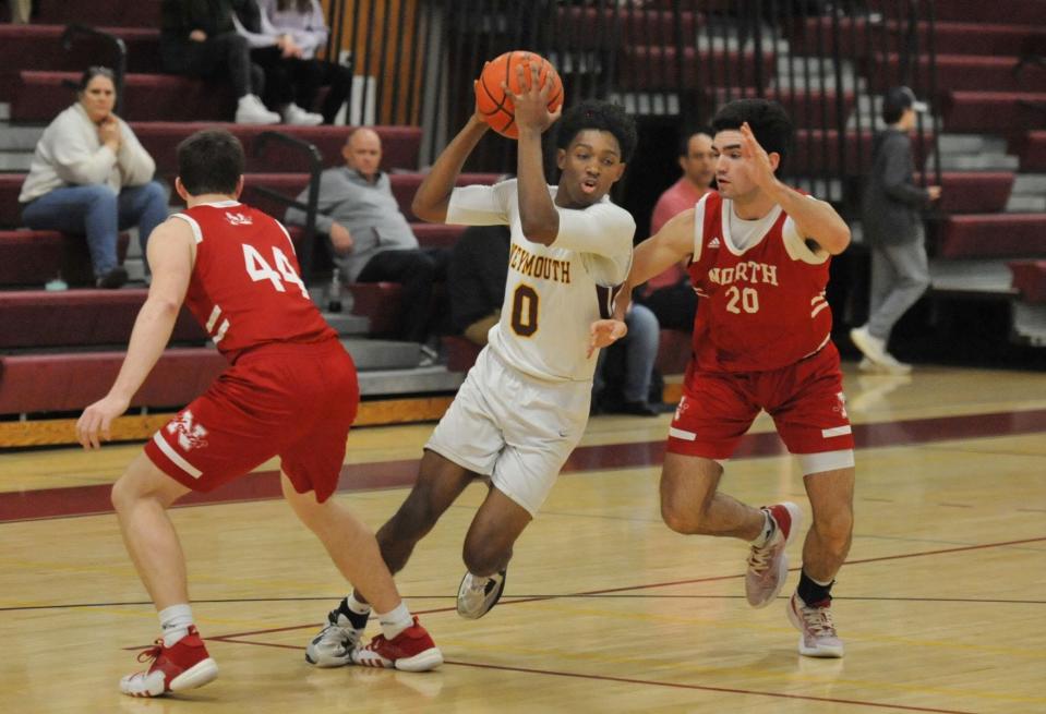 Weymouth's Edric Louissaint, center, races to the paint as he splits North Attleborough's Jack Murley, left, and Chace Frisoli, right, during boys basketball action at Weymouth High School, Monday, Monday, Feb. 20, 2023.