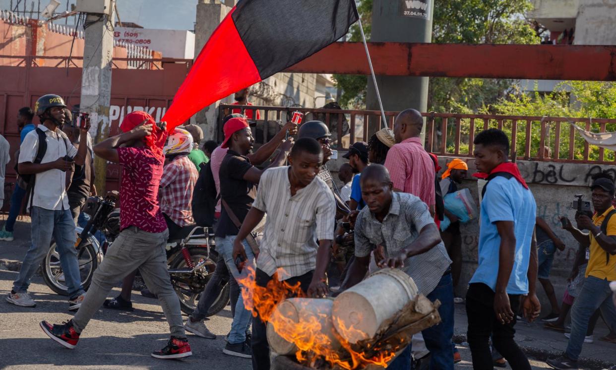 <span>People set tyres on fire during a demonstration demanding the resignation of the Haitian prime minister, Ariel Henry, in Port-au-Prince on 7 March.</span><span>Photograph: Anadolu/Getty Images</span>