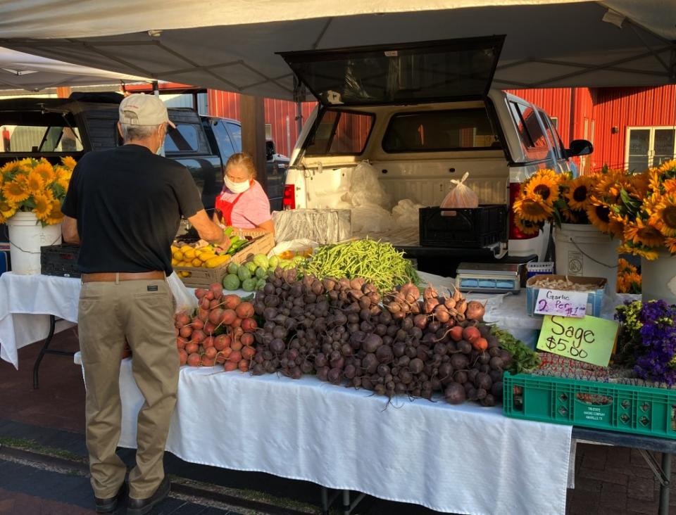 A customer at a booth at the Santa Fe Saturday Farmers Market via Getty Images