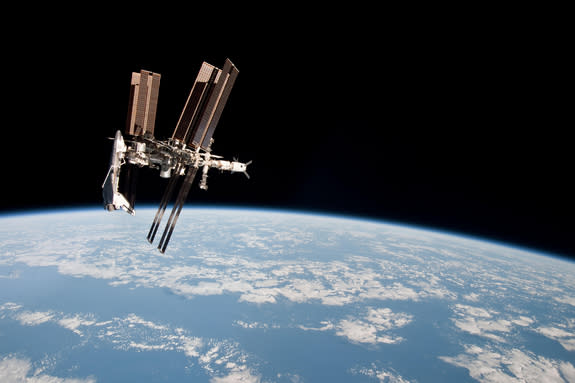 NASA's space shuttle Endeavour appears to hang off one end of the International Space Station in this photo taken by an astronaut aboard a nearby Soyuz spacecraft on May 23, 2011 during Endeavour's final mission. It is one of the first-ever ima