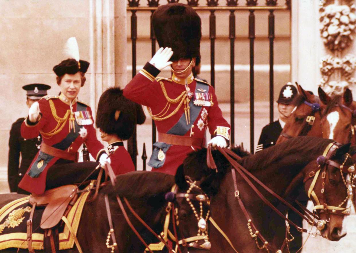 Britain's Queen Elizabeth II and her husband Prince Philip take the salute on horseback outside the gates of Buckinghma Palace, London, on June 14, 1975, following the annual Trooping of the Colour ceremony.