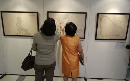 Visitors point at an ancient map on display at a Catholic university in Manila September 11, 2014. REUTERS/Romeo Ranoco