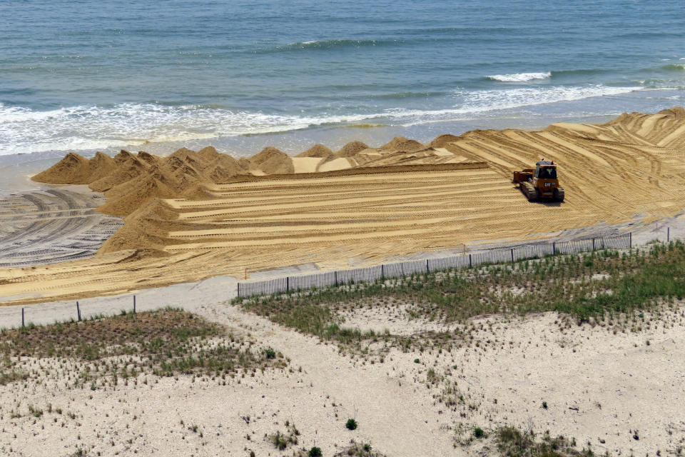 A bulldozer spreads freshly dumped sand on the beach in front of the Ocean Casino Resort in Atlantic City, N.J., Friday, May 12, 2023. The casino is spending up to $700,000 of its own money to rebuild the eroded beach, deciding it cannot wait another year or two for the next government-funded beach widening project scheduled for the area. (AP Photo/Wayne Parry)