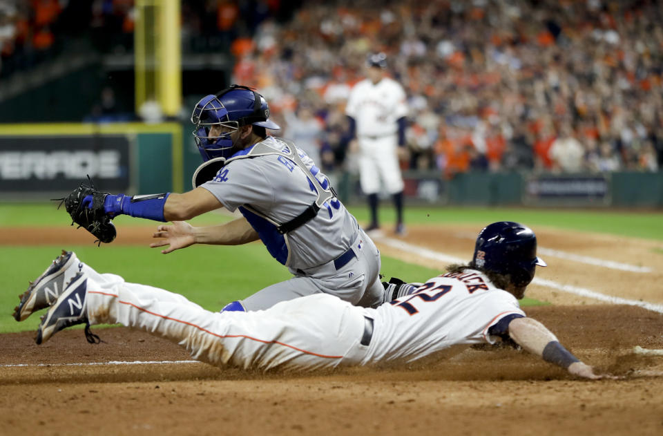 Houston's Josh Reddick slides safely past Dodgers catcher Austin Barnes to score on Marwin Gonzalez's second-inning single. (AP)