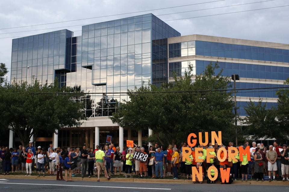 FILE - In this Aug. 5, 2019, file photo, people gather at a vigil for recent victims of gun violence outside the National Rifle Association's headquarters building in Fairfax, Va. The NRA has been embroiled in a legal and financial battle that liberals have cheered as the potential downfall of the powerful gun rights lobby, opening up a wide path for reform. Not so fast. While the battle over gun rights is shifting from Washington to the states, the NRA’s message has become so solidified in the Republican political fabric that it’s self-sustaining, even if the gun rights organization that led the way ceases to exist, leaders on both sides say. (AP Photo/Patrick Semansky, File)