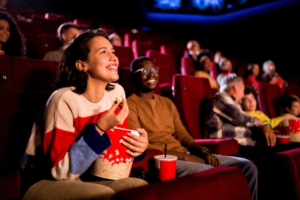 girl smiling eating popcorn at the movies