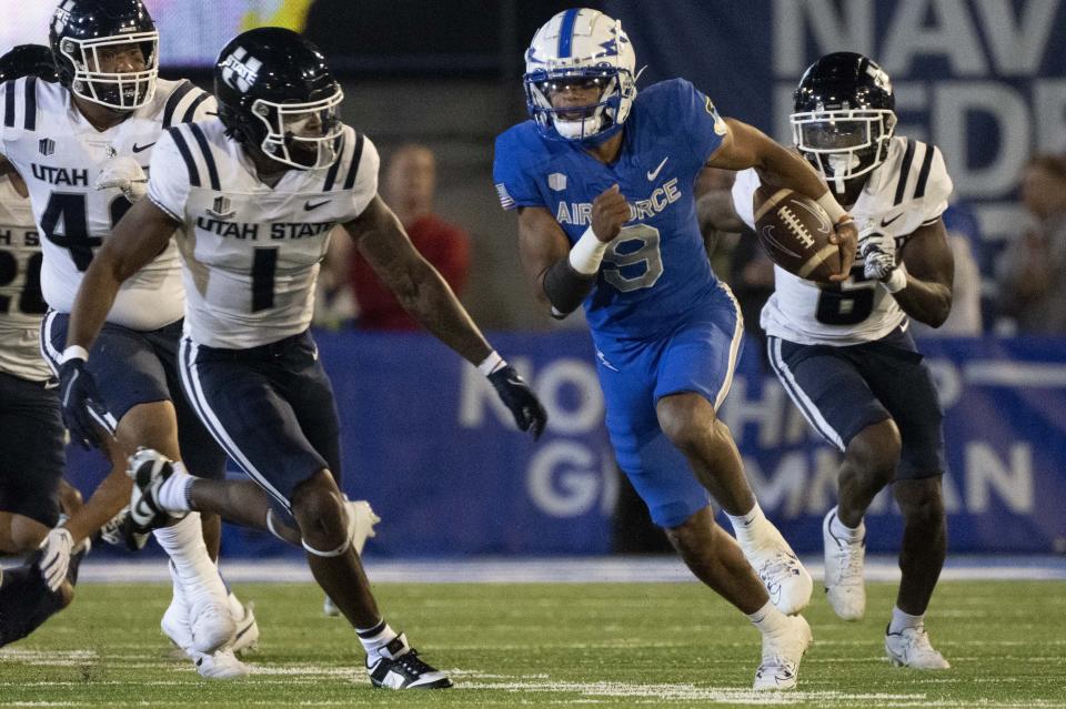 Air Force quarterback Zac Larrier (9) runs downfield for a first down against Utah State safeties Anthony Switzer (1) and Ike Larsen (6) during the first half of an NCAA college football game in Air Force Academy, Colo., Friday, Sept. 15, 2023. | Christian Murdock/The Gazette via AP