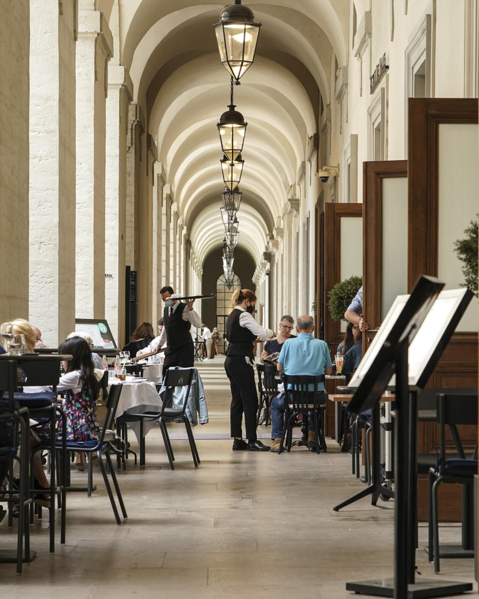 People enjoy a meal in a restaurant during the nationwide reopening of restaurants, in Lyon, central France, Wednesday, June 9, 2021. (AP Photo/Laurent Cipriani)