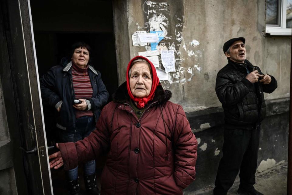 People stand at the doorway to a basement they use as a bomb shelter