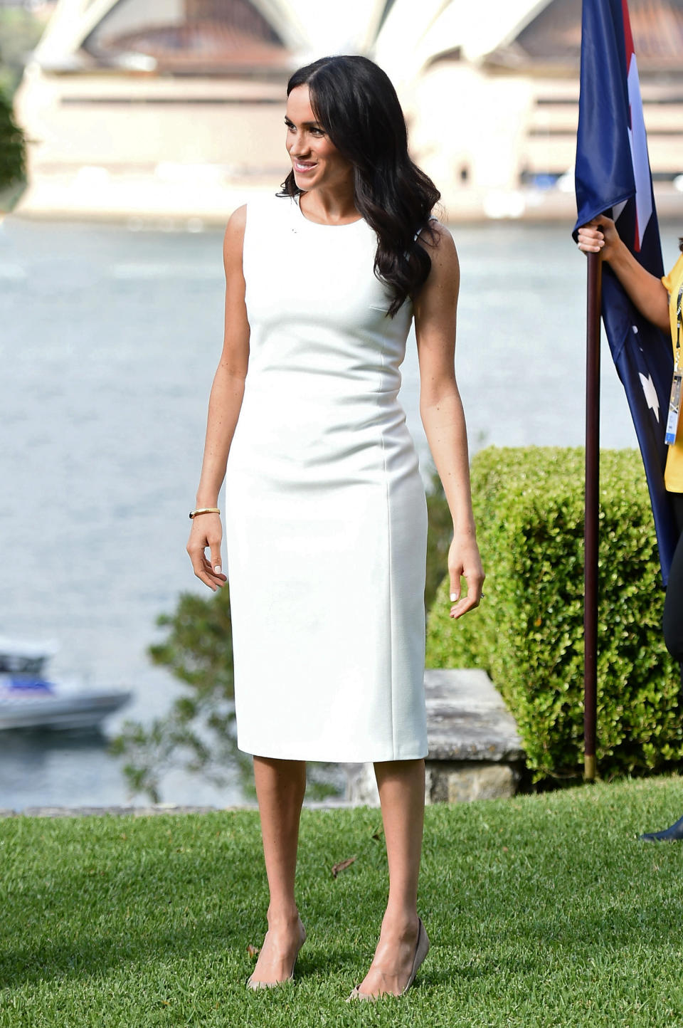 <p>Meghan dressed diplomatically for her first engagement at Sydney’s Opera House, wearing <a rel="nofollow noopener" href="https://karengee.com/blessed-dress.html" target="_blank" data-ylk="slk:a £940 white, sheath dress by Australian designer Karen Gee;elm:context_link;itc:0;sec:content-canvas" class="link ">a £940 white, sheath dress by Australian designer Karen Gee</a>. She finished the look with a pair of butterfly earrings and a delicate gold bracelet from Princess Diana’s former collection. <em>[Photo: Getty]</em> </p>