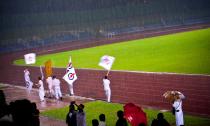 Sembawang GRC volunteers run along the tracks under the rain to keep rally spirits up at the Woodlands stadium. (Yahoo! photo/ Liyana Low) 