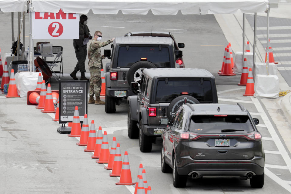 A member of the Florida National Guard directs vehicles at a COVID-19 testing site at the Miami Beach Convention Center during the coronavirus pandemic, Sunday, July 12, 2020, in Miami Beach, Fla. Florida on Sunday reported the largest single-day increase in positive coronavirus cases in any one state since the beginning of the pandemic. (AP Photo/Lynne Sladky)