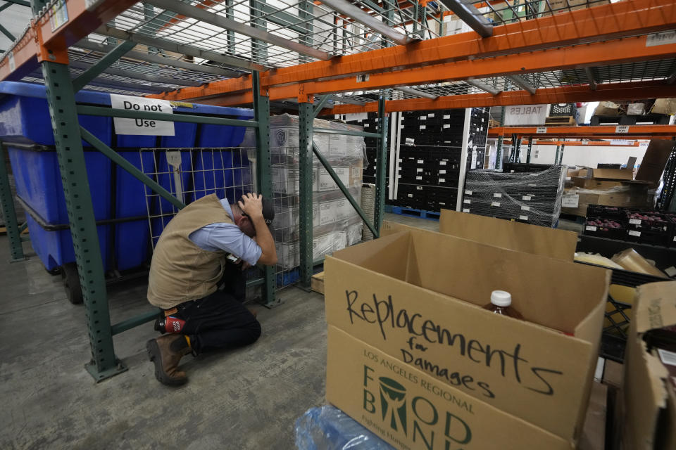 People participate at a ShakeOut earthquake drill at the Los Angeles Regional Food Bank in Los Angeles Thursday, Oct. 19, 2023. Up and down the West Coast, the ShakeOut drill was scheduled to begin at 10:19 a.m. PDT with a cellphone-rattling test alert from the region's ShakeAlert earthquake warning system. (AP Photo/Damian Dovarganes)