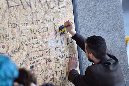 A man is painting a Swedish flag. People gathering at the crash site at Ahlens department store following Friday's terror attack in central Stockholm, Sweden, Sunday, April 9, 2017. Noella Johansson/TT News Agency via REUTERS