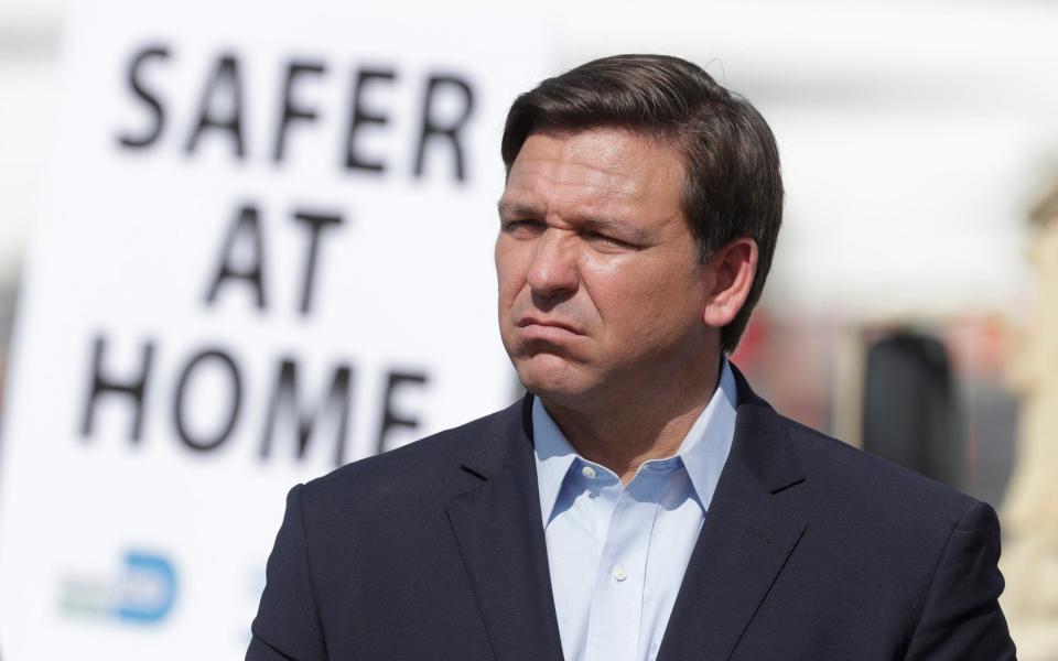 Florida Gov. Ron DeSantis listens during a news conference at a drive-through coronavirus testing site in front of Hard Rock Stadium - AP