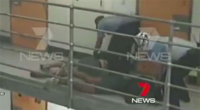 Guards cuff the two inmates before leading them downstairs. Photo: 7 News