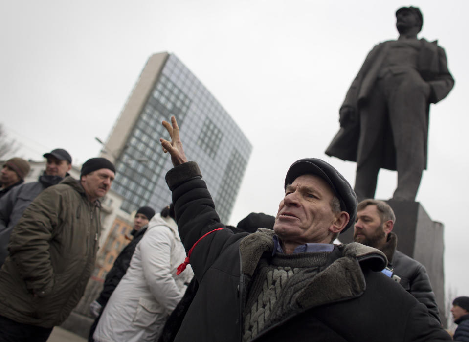 In this photo taken Wednesday, Feb. 26, 2014, a man shouts pro-Russian slogans below a monument of Vladimir Ilyich Lenin, in Donetsk, eastern Ukraine. If Ukraine looks neatly delineated on maps, its history is a tangle of invasions and occupations and peoples and religions, a place of ill-defined borders that for centuries has been struggling to define itself. The modern nation is so sharply divided by culture and loyalty, split between allegiance to Moscow and allegiance to Western Europe, that it often can appear ready to simply snap in two. (AP Photo/Darko Bandic)