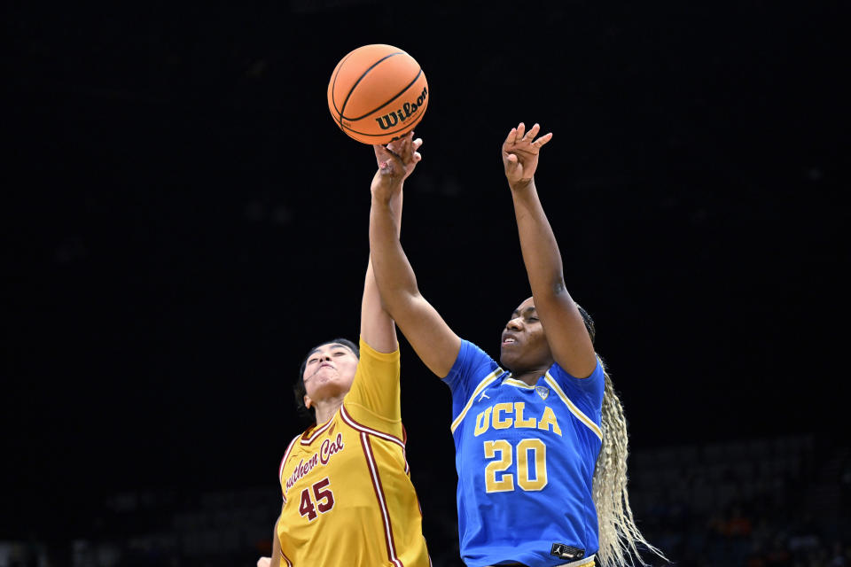 UCLA guard Charisma Osborne (20) draws a foul from Southern California guard Kayla Padilla (45) while shooting during the first half of an NCAA college basketball game in the semifinals of the Pac-12 women's tournament Friday, March 8, 2024, in Las Vegas. (AP Photo/David Becker)