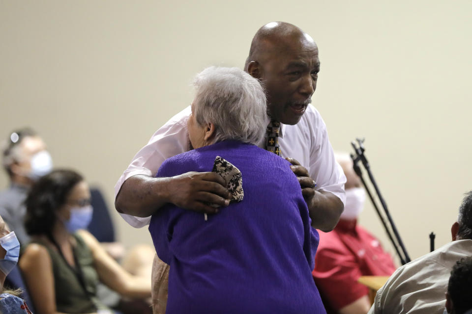 Beth Thompson, of Jackson, La., hugs Rev. George Veal, pastor of Mount Cavalry and Richland Baptist Church in Norwood, La., after Veal spoke at a town hall meeting to discuss the removal of a Confederate soldier statue in front of the East Feliciana Parish courthouse in Clinton, La., on June 30, 2020. As protests sparked by the death of George Floyd in Minneapolis focus attention on the hundreds of Confederate statues still standing across the Southern landscape, officials in the rural parish of roughly 20,000 people recently voted to leave the statue where it is. (AP Photo/Gerald Herbert)