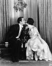 <p>Actors Buddy Rogers and Mary Brian share a kiss under the mistletoe. The actress wore a chiffon ball gown with a bateau neckline and festive satin trimmings. </p>