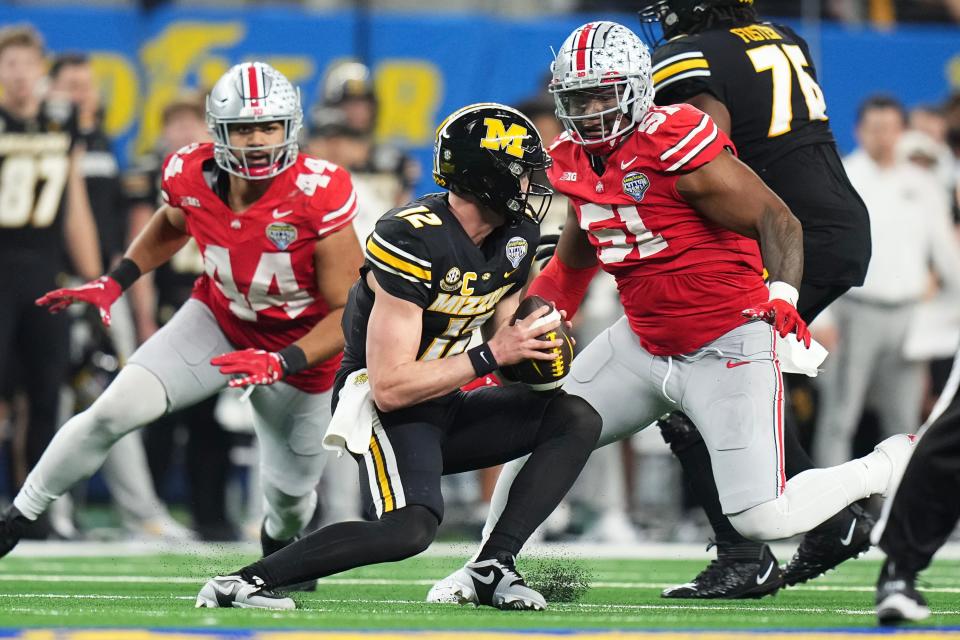 Dec 29, 2023; Arlington, Texas, USA; Ohio State Buckeyes defensive tackle Michael Hall Jr. (51) and defensive end JT Tuimoloau (44) pursue Missouri Tigers quarterback Brady Cook (12) during the third quarter of the Goodyear Cotton Bowl Classic at AT&T Stadium. Ohio State lost 14-3. Credit: Adam Cairns/Columbus Dispatch-USA TODAY NETWORK