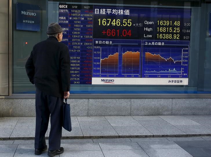 A man looks at an electronic board displaying the Nikkei average outside a brokerage in Tokyo, Japan, March 2, 2016. REUTERS/Thomas Peter