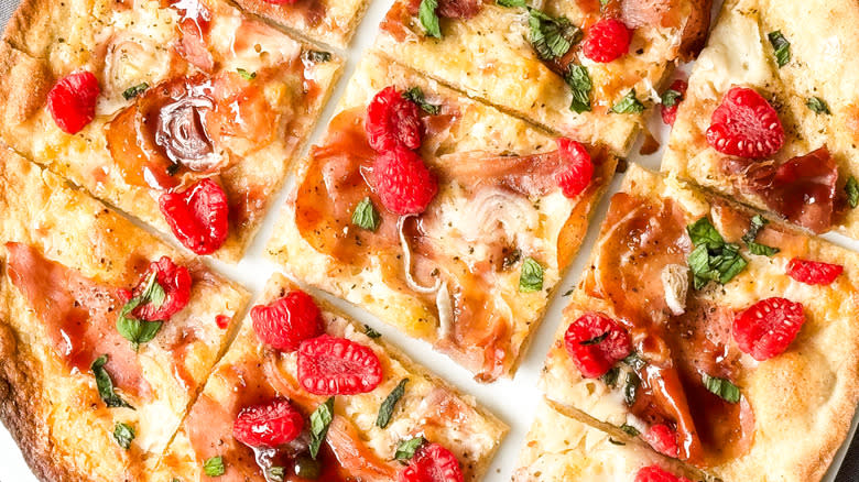 Rye flatbreads with prosciutto and raspberry in slices with raspberry glaze