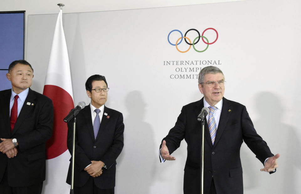 Japanese Olympic Committee President Yasuhiro Yamashita, from left, and Sapporo Mayor Katsuhiro Akimoto listen to International Olympic Committee President Thomas Bach, right, speak during a news conference in Lausanne, Switzerland, on Jan. 11, 2020. Sapporo's bid for the 2030 Winter Olympics has been slowed, but not stopped, by fallout from the still-developing corruption scandal around the 2020 Tokyo Games. (Masashi Inoue/Kyodo News via AP)