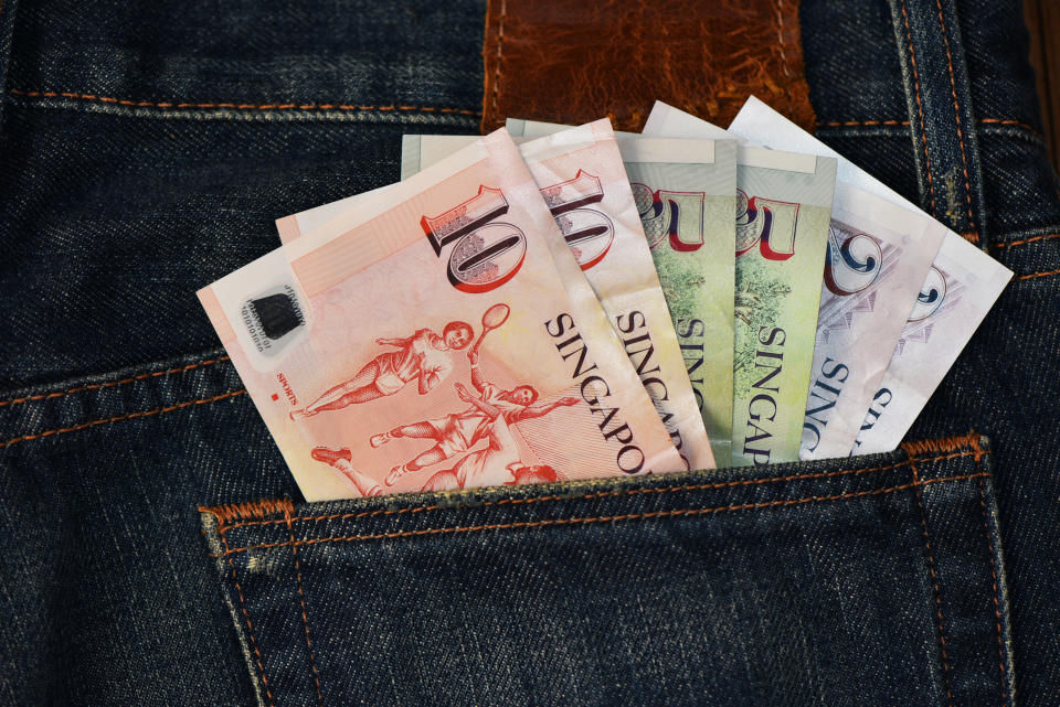 Singapore currency notes in jeans back pocket, illustrating a story on T-bills.