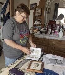 Dixie Clark pages through photo albums showing her and her siblings.  Her brother David Bauer completed suicide in 1999.