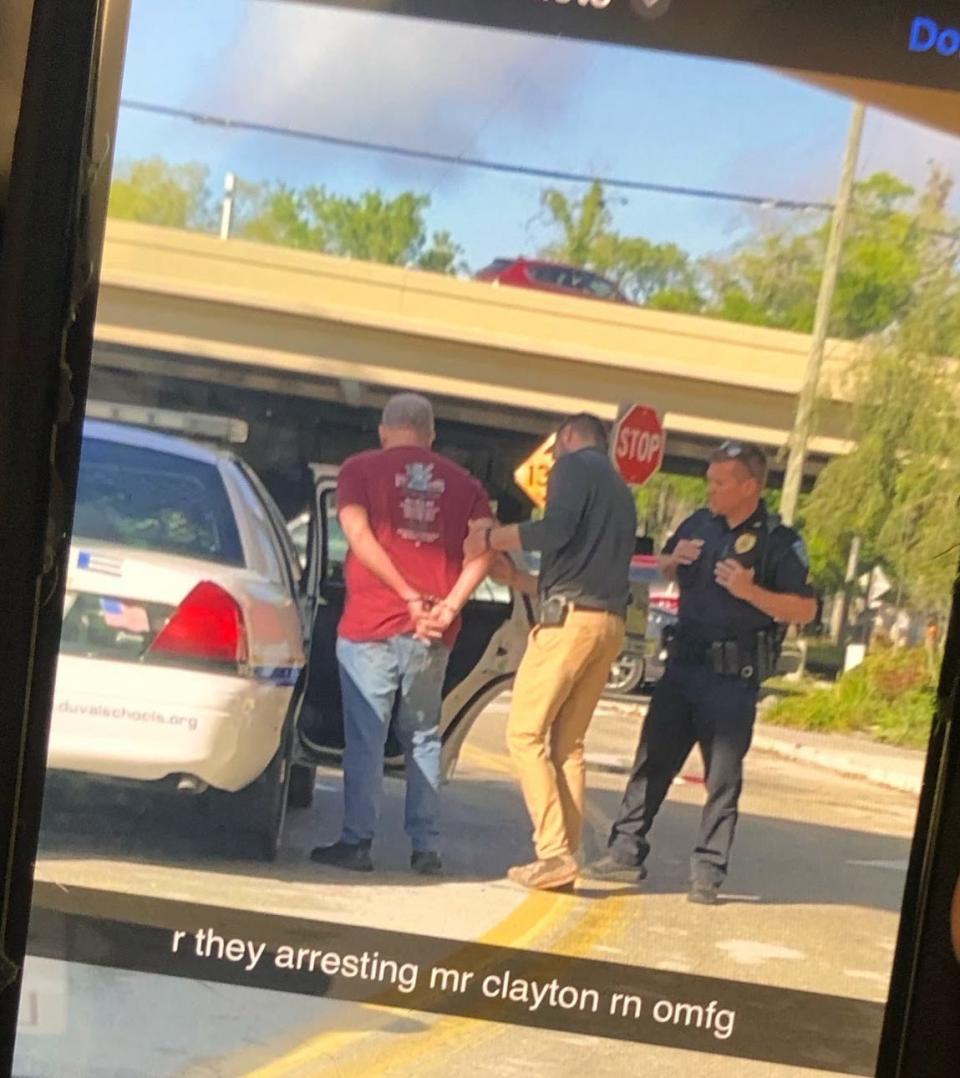 A parent of a Douglas Anderson School of the Arts student shared a cell-phone photo Wednesday of a man being placed in a police car. The parent said the man appeared to be teacher Jeffrey Clayton.