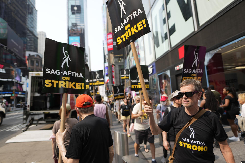 Actor Dylan Baker, right, carries a sign on a picket line outside Paramount in Times Square on Monday, July 17, 2023, in New York. The actors strike comes more than two months after screenwriters began striking in their bid to get better pay and working conditions and have clear guidelines around the use of AI in film and television productions. (Photo by Charles Sykes/Invision/AP)