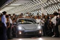 Employees take pictures of a Volkswagen Beetle car during a ceremony marking the end of production of VW Beetle cars, at company's assembly plant in Puebla