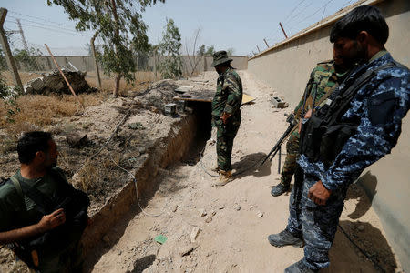 Fighters from the Iraqi Shi'ite Badr Organization look at a tunnel built by Islamic State fighters on the outskirts of Falluja, Iraq, May 28, 2016. REUTERS/Thaier Al-Sudani