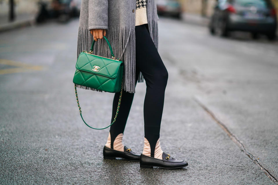 PARIS, FRANCE - DECEMBER 14: Gabriella Berdugo wears a gray wool coat with fringes from Dorothee Schumacher, black leggings with strappy legs, black leather Gucci loafers shoes, a green quilted leather Chanel bag, on December 14, 2020 in Paris, France. (Photo by Edward Berthelot/Getty Images)