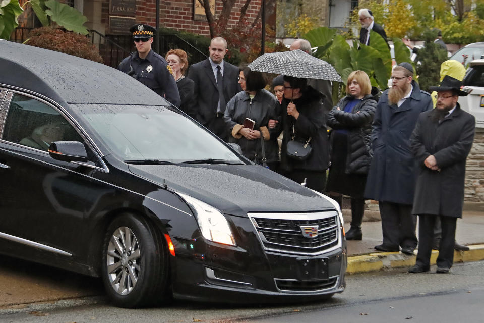 Mourners watch as the hearse carrying the casket of Richard Gottfried leaves the Ralph Schugar Funeral home in Pittsburgh following a memorial service Nov. 1, 2018. Mr. Gottfried, 65, was one of 11 people killed while worshipping when a gunman opened fire at the Tree of Life Synagogue on Saturday Oct. 27, 2018. (AP Photo/Gene J. Puskar)