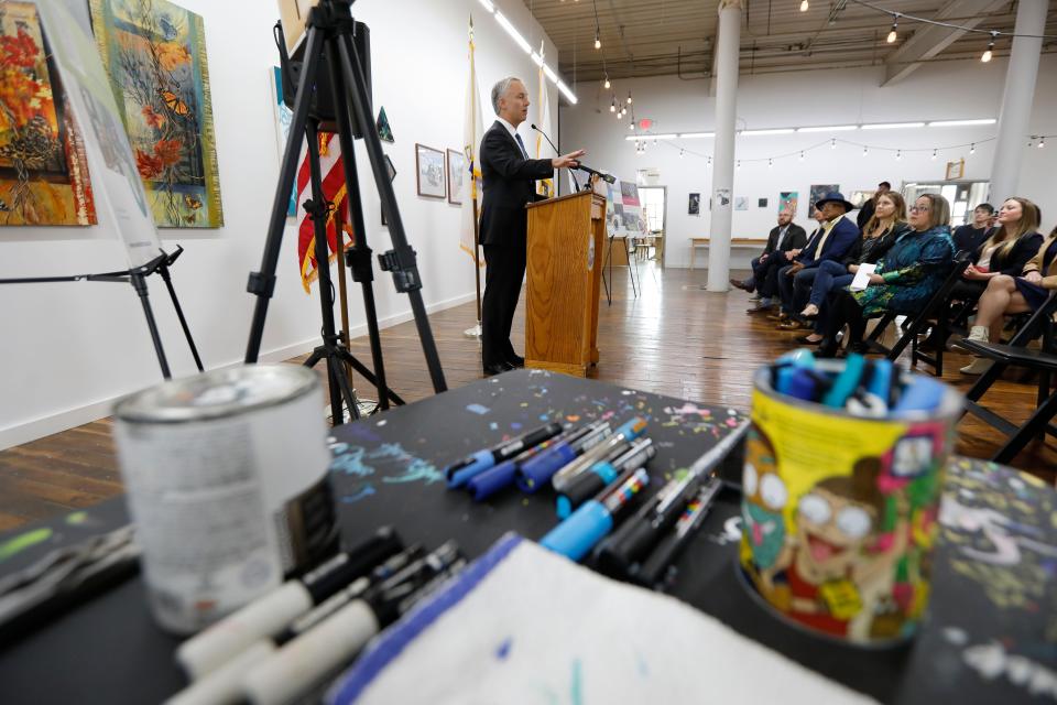 Art supplies are seen in the foreground as Mayor Jon Mitchell announces a dynamic new funding and support program for local artists at an event held at the Hatch Street Studios in New Bedford.